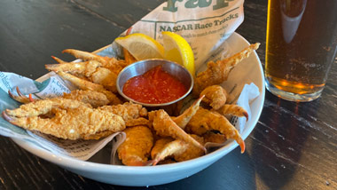 fried crab strips with cocktail sauce and a beer