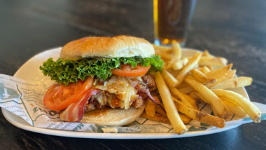 chicken sandwich with bacon, cheese, fried onions, lettuce & tomato and fries
