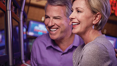 A senior couple smiles while playing a slot machine at Hollywood Casino in St. Louis, Missouri.