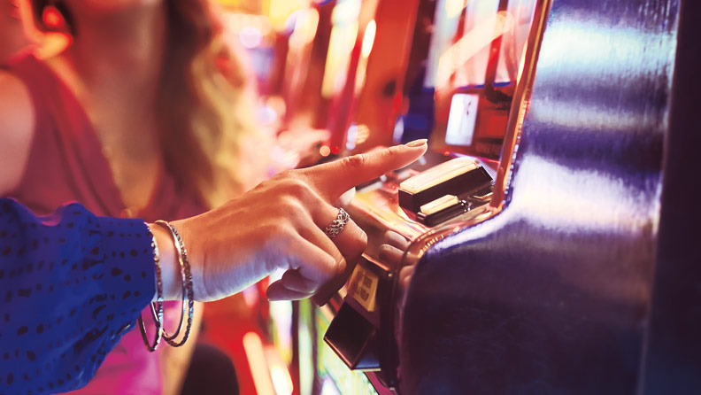 woman pushing button on a slot machine